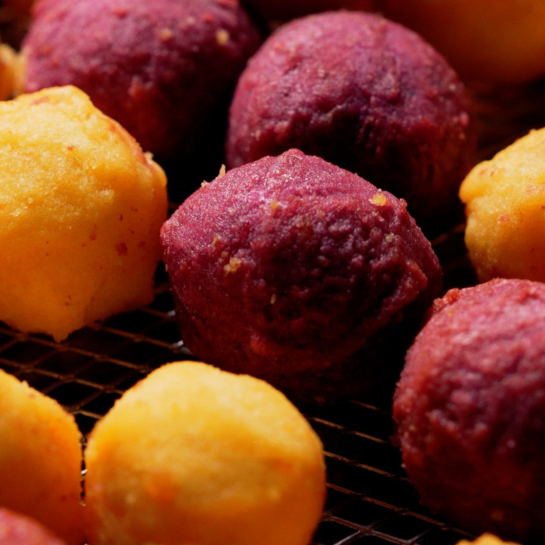 Lumo baked sweet potato balls in yellow and purple, oven-cooked and crispy close-up.